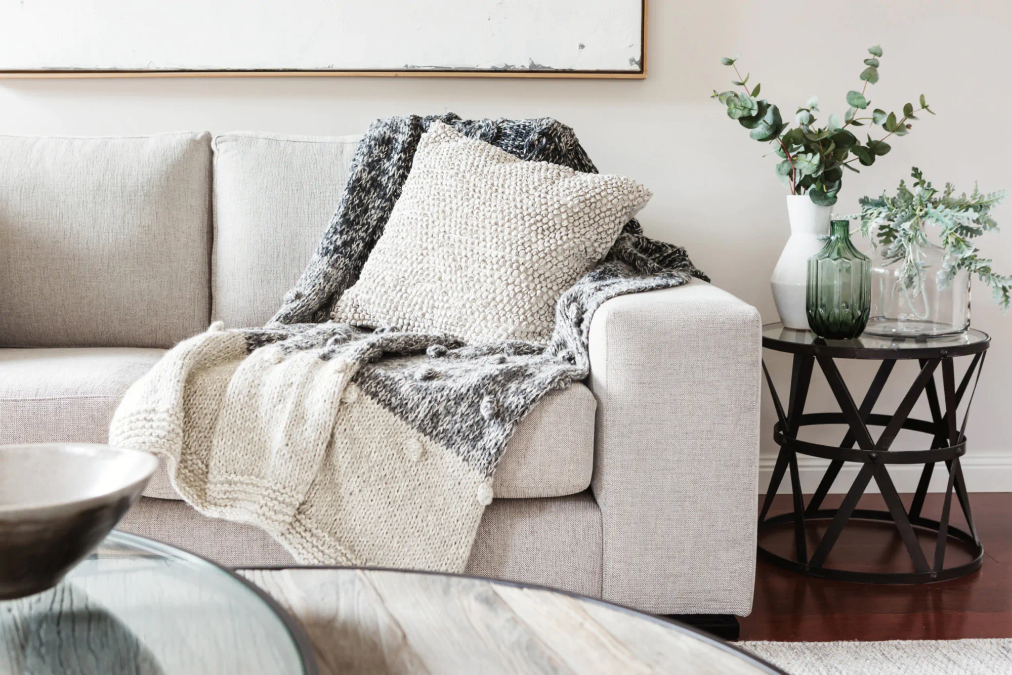 Cream couch with textured blankets and pillows in neutral colors.