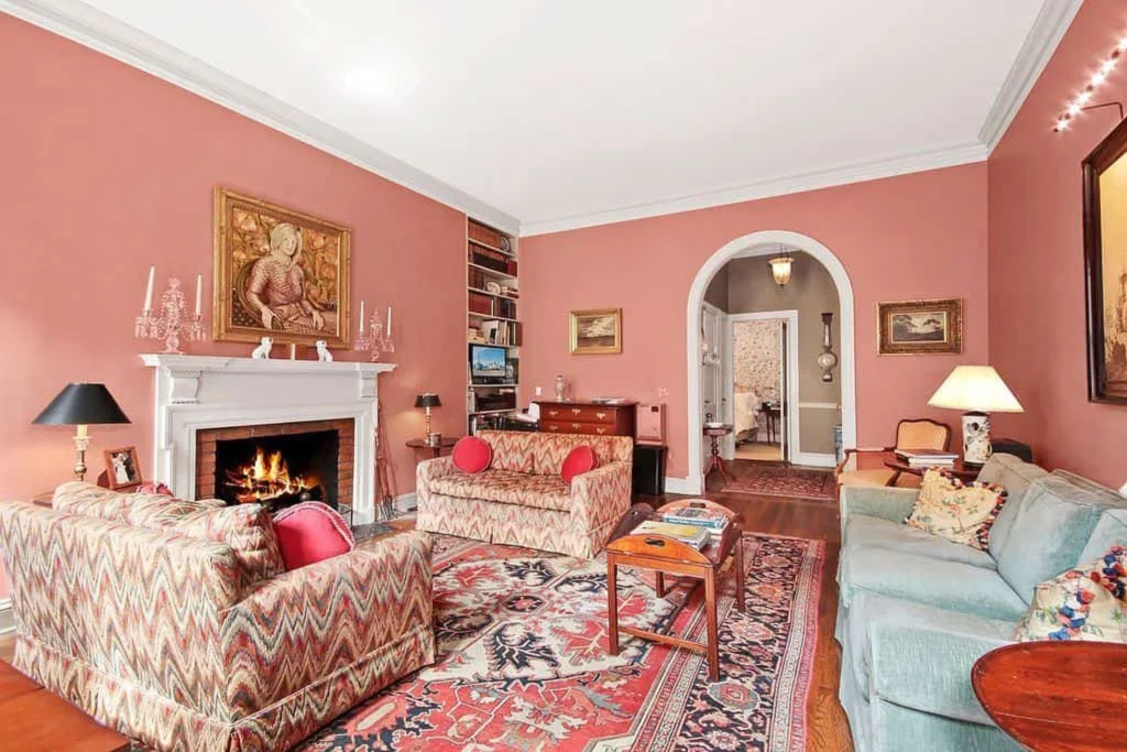 Pink living room with patterned couches. 