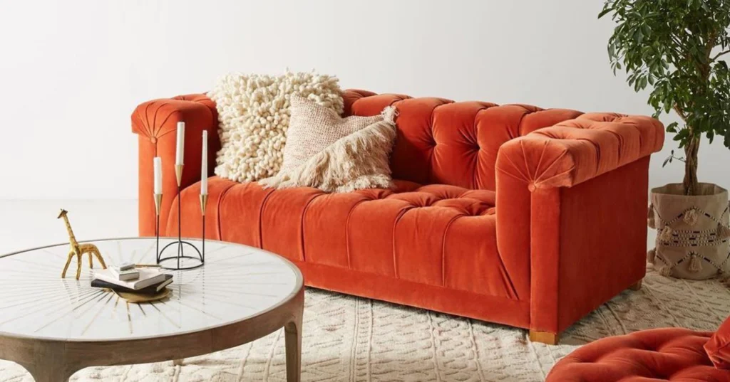 Burnt orange sofa with tufting design.