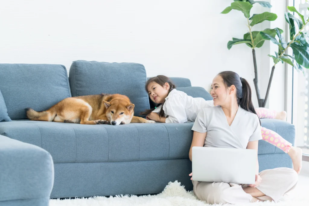 Woman with dog and daughter on a blue couch.