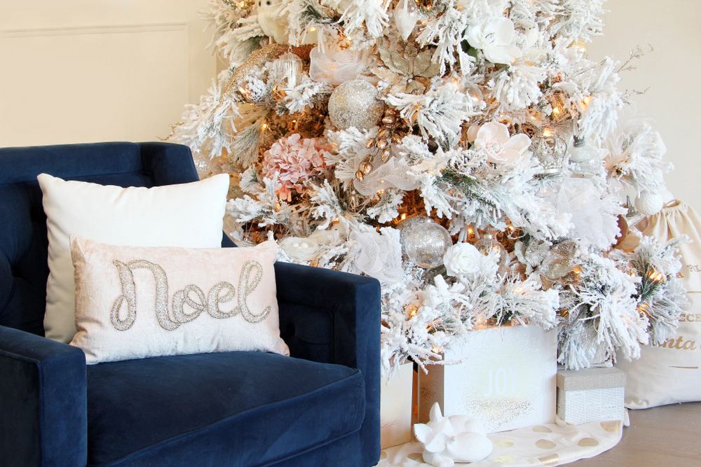 Dark navy velvet armchair next to a white Christmas tree.